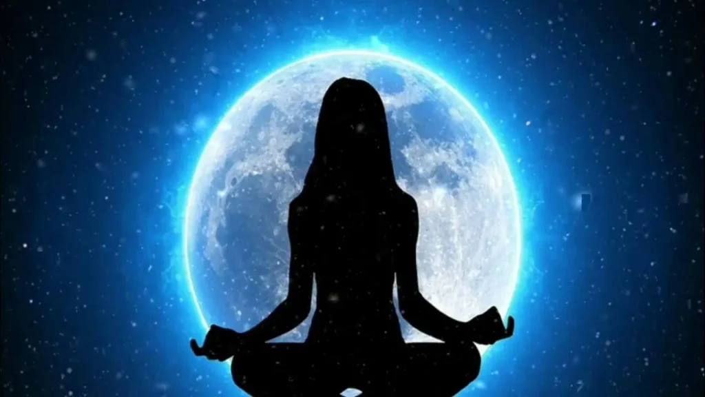 Imagem de uma mulher em posição de meditação sob a luz da Lua cheia, simbolizando a prática de autocuidado e intuição guiada pelo mapa lunar